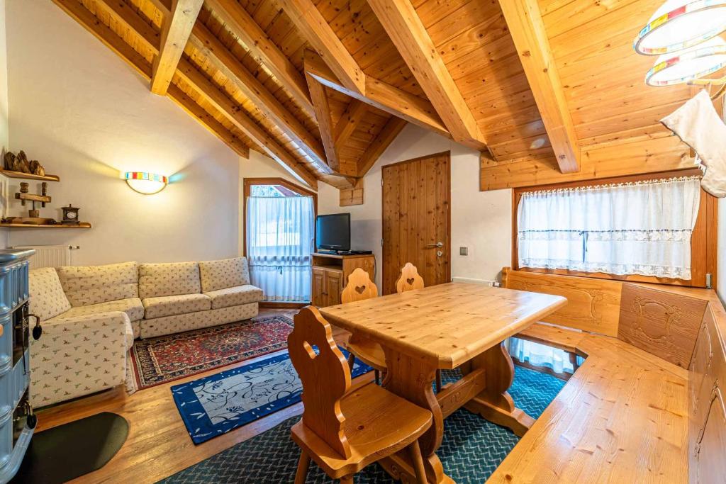 阿拉巴的住宿－Tabià La Stua，客厅配有木桌和沙发