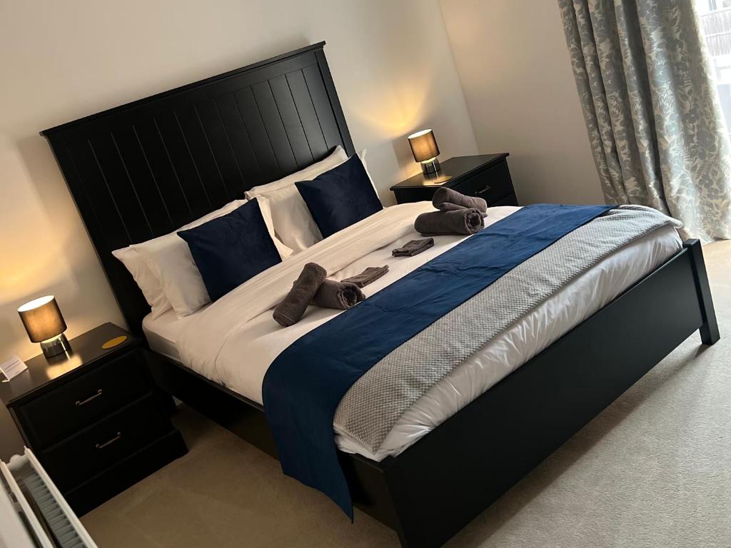 a bedroom with a large bed with blue sheets at Fabulous Modern Apartment Close to Central Milton Keynes in Milton Keynes