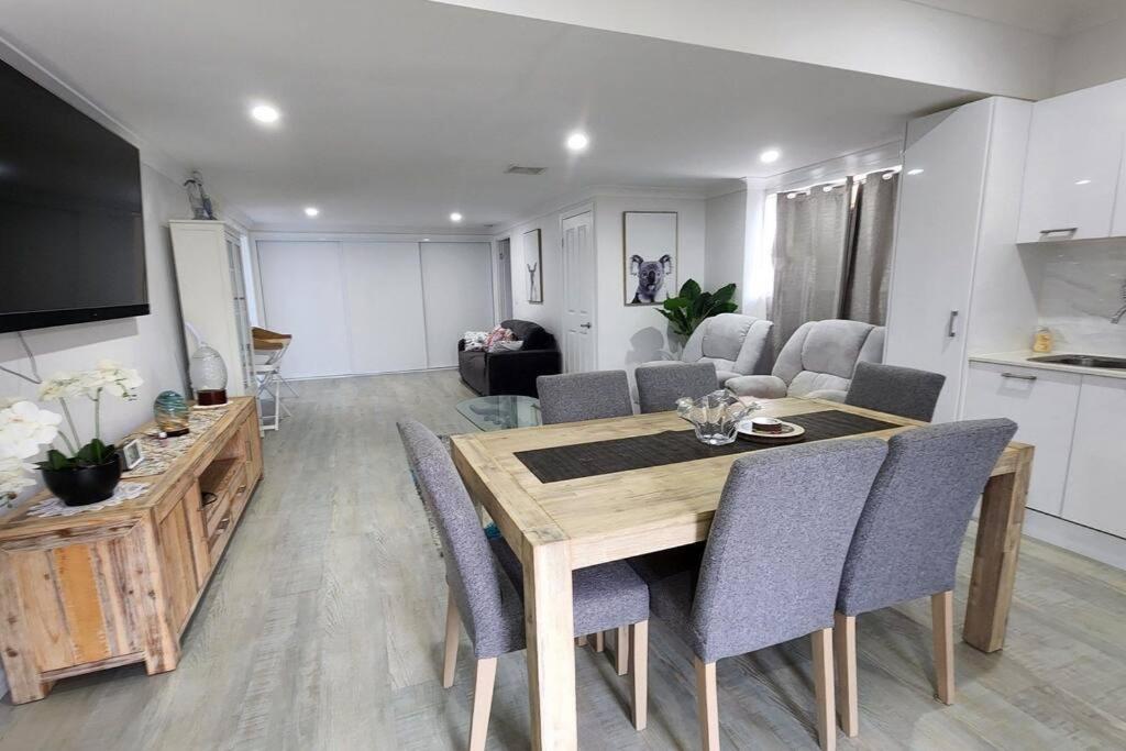 a kitchen and dining room with a table and chairs at Oscar's at Banora in Kurrara