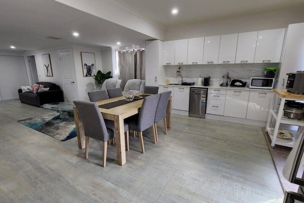 a kitchen and dining room with a table and chairs at Oscar's at Banora in Kurrara