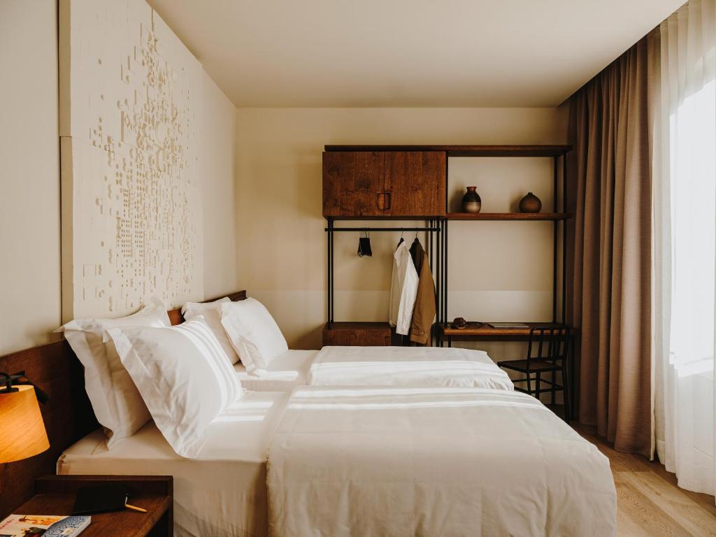 a hotel room with a bed and a dresser at Sonder Casa Luz in Barcelona