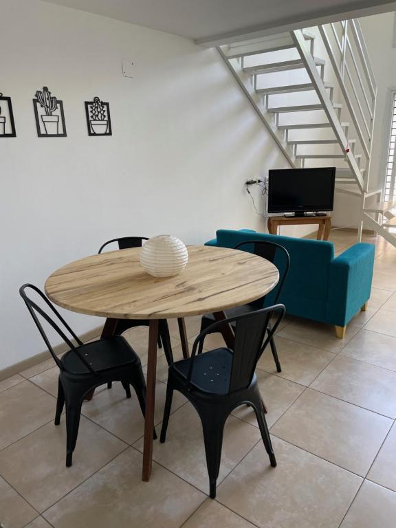 una mesa y sillas en una sala de estar con sofá en Hermoso Departamento Tipo Loft -Mendoza en Godoy Cruz