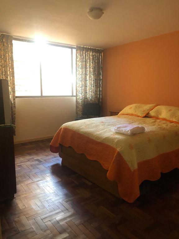 um quarto com uma cama e uma grande janela em Céntrico apartamento em La Paz