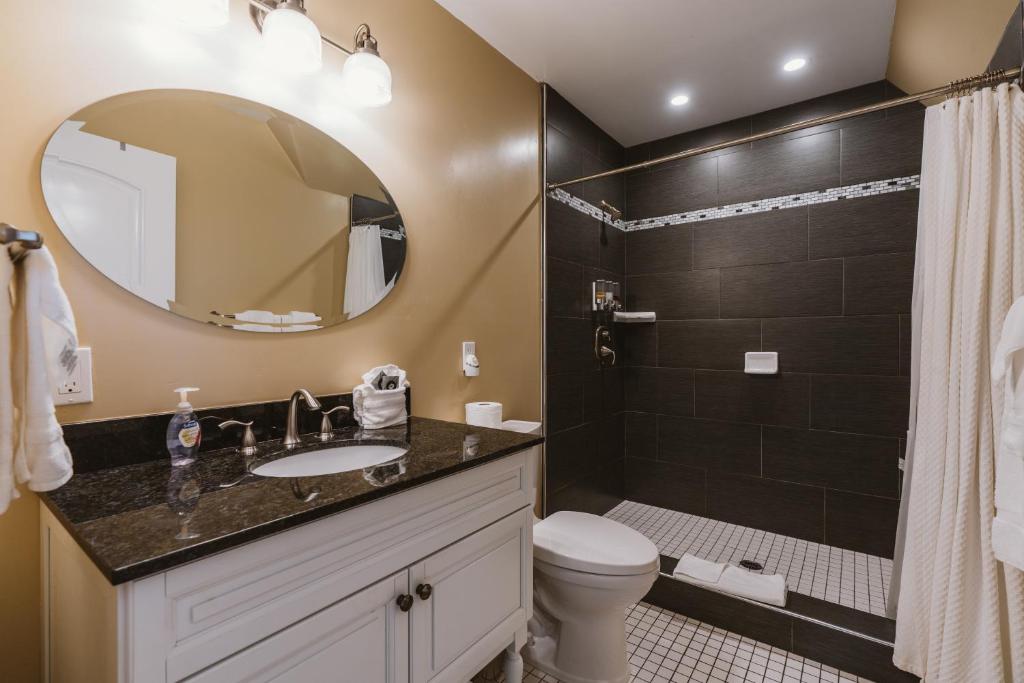a bathroom with a sink and a toilet and a mirror at New Haven Inn in Solvang