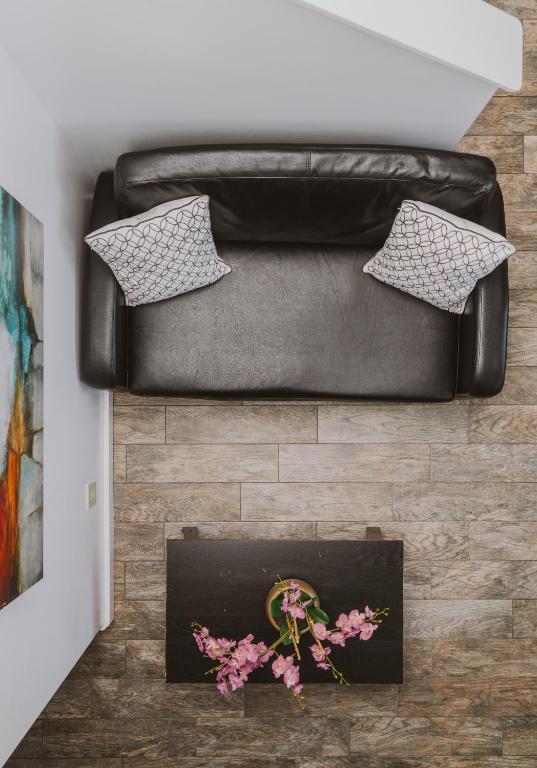 a black leather couch with a table and flowers on it at New Haven Inn in Solvang