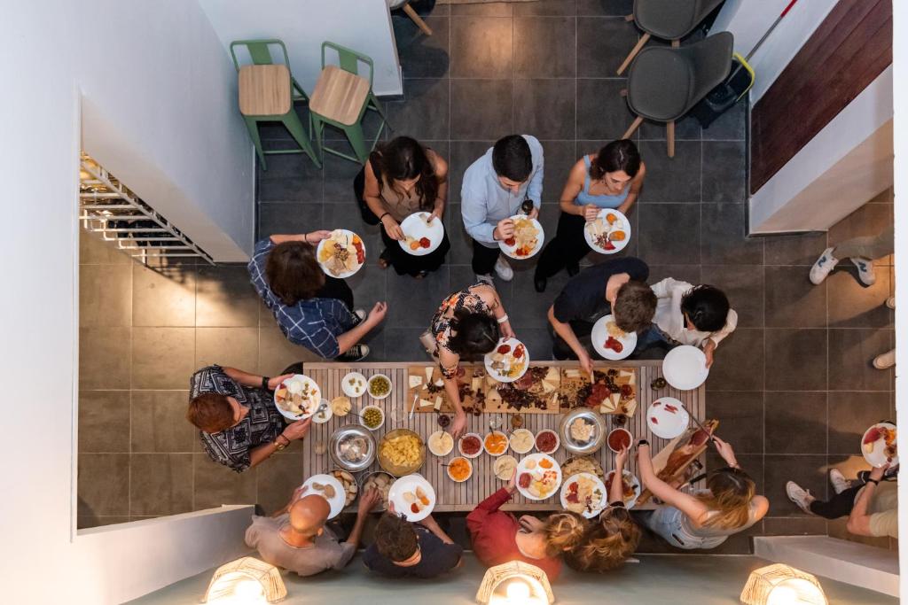 Compass House في لاس بالماس دي غران كاناريا: مجموعة من الناس يجلسون حول طاولة يأكلون الطعام
