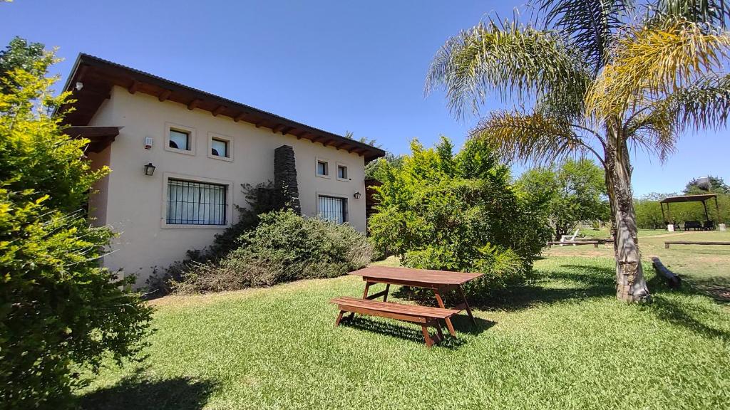 a picnic table in the grass in front of a house at Altos del Campo in San José