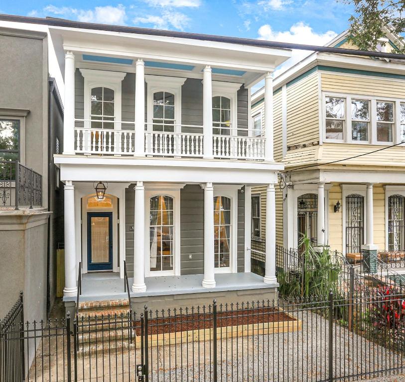 a large white house with a porch and columns at Canal Street Mini Mansion Sleeps 15 in New Orleans
