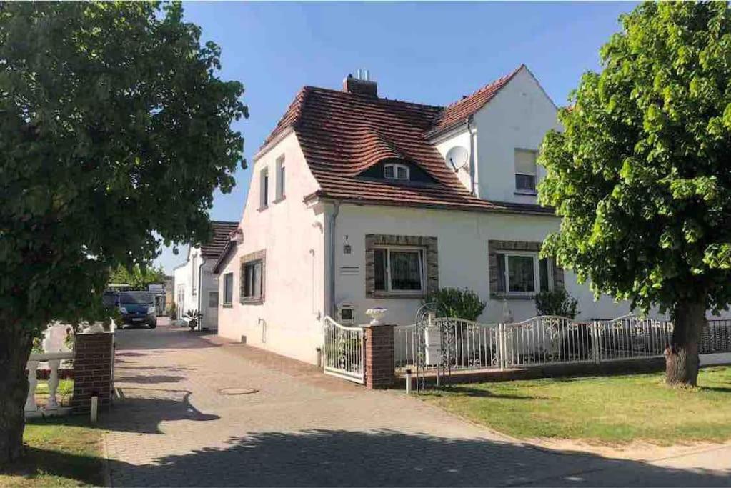 ein weißes Haus mit einem Zaun davor in der Unterkunft Ferienwohnung im Spreewald, Nähe Lübben in Golßen