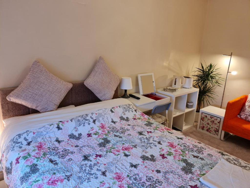 1 dormitorio con 1 cama grande con colcha de flores en KELVIN HOUSE, en Durham