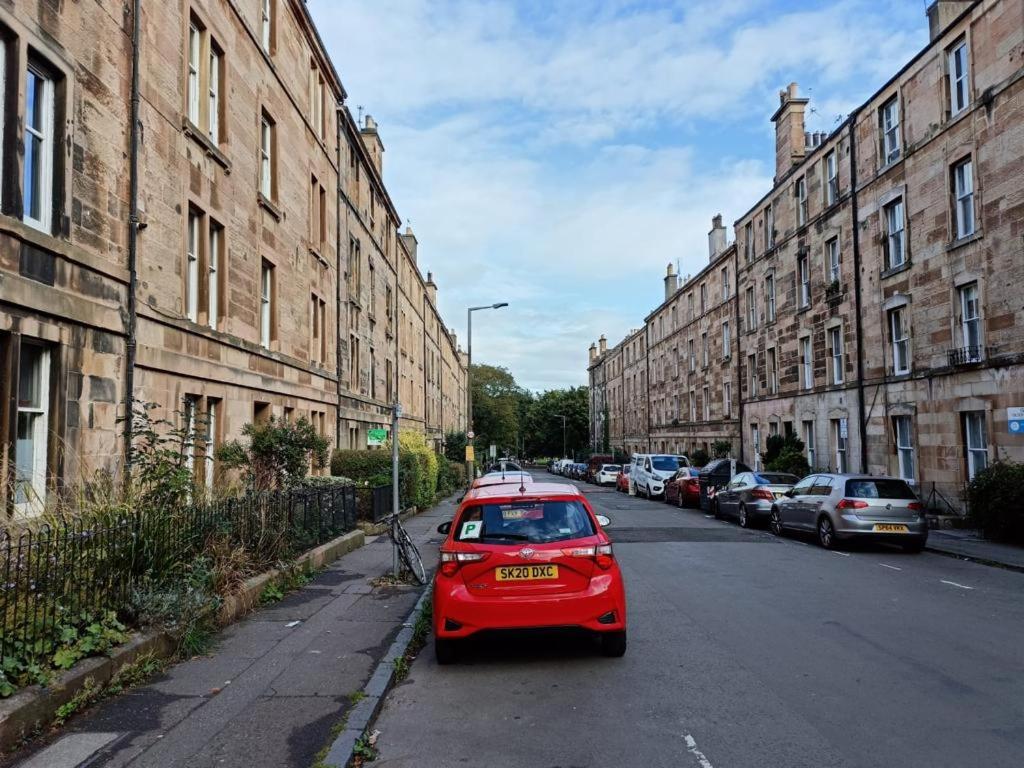 ein rotes Auto, das an der Straßenseite geparkt ist in der Unterkunft City centre Flat - sleep upto 4 in Edinburgh