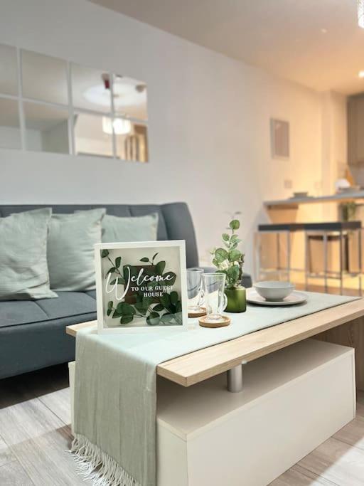 uma sala de estar com uma mesa com uma fotografia em New Build Cosy Duplex Modern Apartment Greater Manchester em Stockport