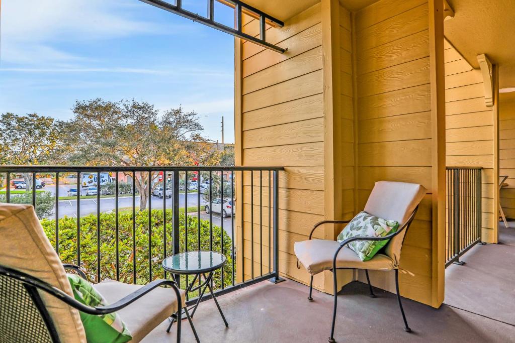 a balcony with chairs and a table and a view at Villa del Sol #324 in Kissimmee