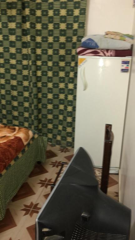 Cette chambre dispose d'un réfrigérateur, d'un lit et d'une télévision. dans l'établissement Sunny sea, à Al-Qusair