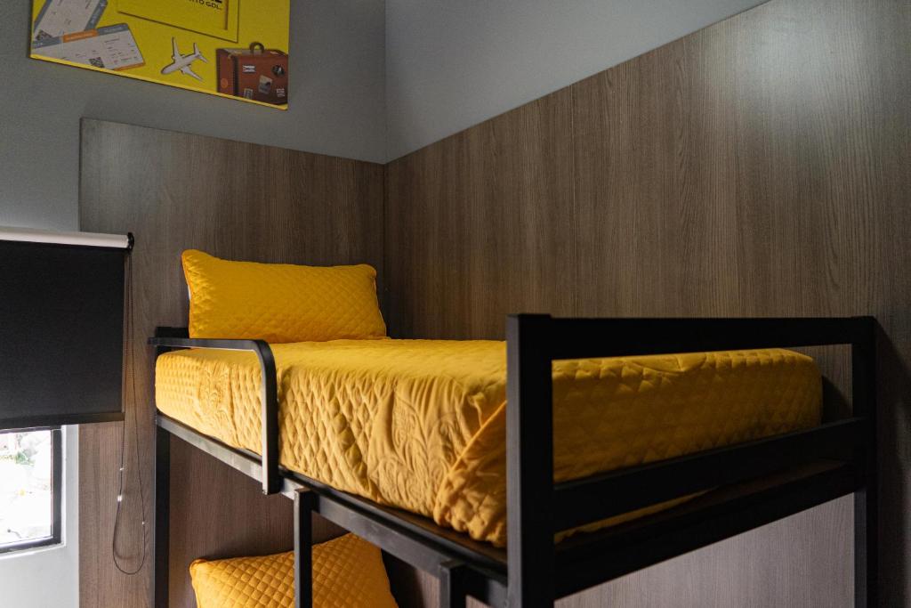 Postel nebo postele na pokoji v ubytování CHECK INN HOSTAL AEROPUERTO GDL