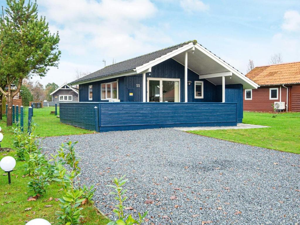 una casa azul con una entrada de grava delante de ella en Holiday Home Haregade II en Hovborg