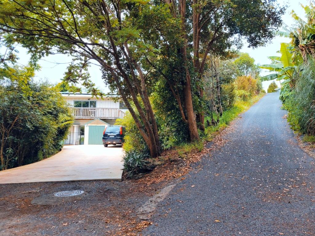 a driveway with a car parked in front of a house at Garden Bliss & Bird Sanctuary in Paihia Estuary in Paihia