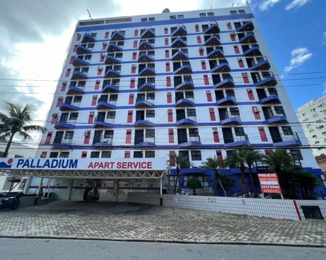 a large building with a sign in front of it at FLAT PALLADIUM - DE FRENTE - novo in São Vicente