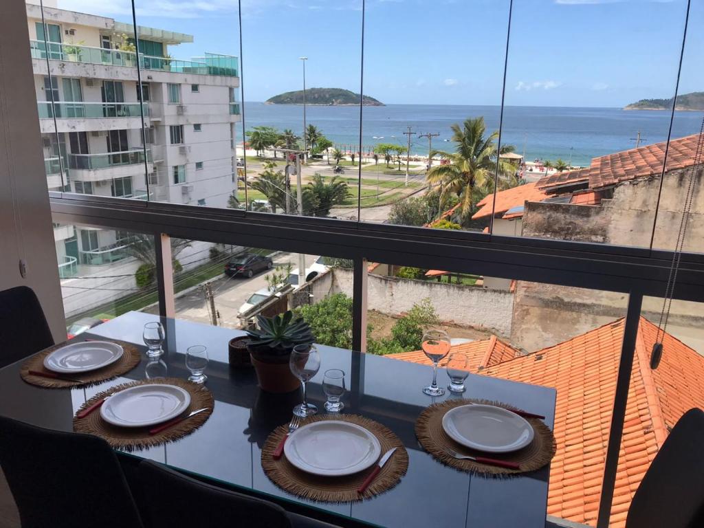 a table with a view of the ocean from a balcony at Maravilhoso Loft vista mar OCEANVIEW in Niterói