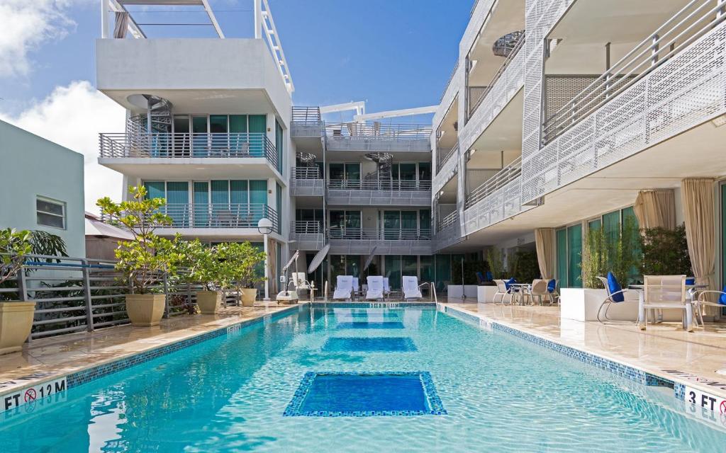 a swimming pool in front of a building at Boutique Suites 3 min walk to beach in Miami Beach
