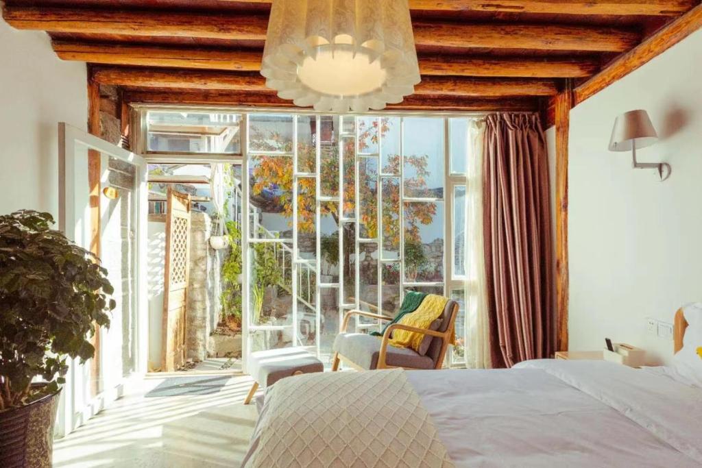 Una cama o camas en una habitación de Honglin Houseg虹林的小院 防疫整栋 古城里温馨私家小院 享受大理慢时光 树下喝茶聊天 烧烤娱乐自助厨房 休闲好去处