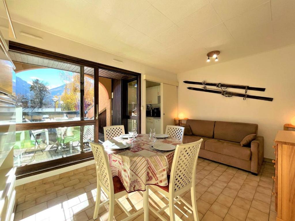 ブリアンソンにあるStudio cosy avec balcon, proche centre et télécabine – Briançon - FR-1-330C-137のテーブルと椅子とソファのあるダイニングルーム