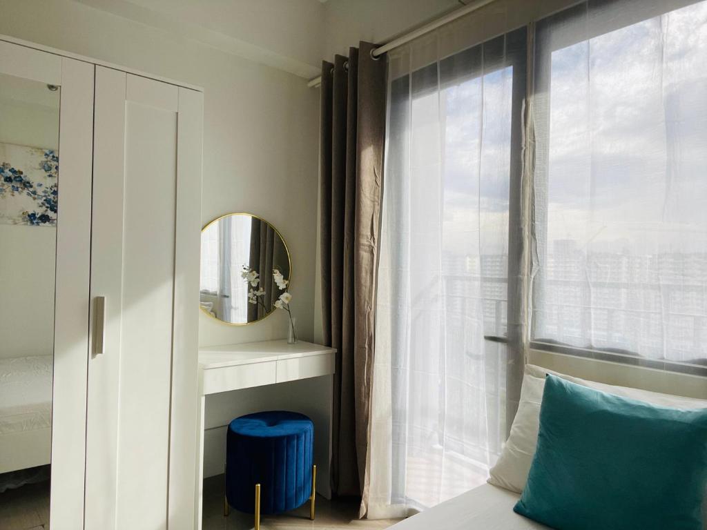 1 dormitorio con cama, espejo y ventana en Sakan 5-Star Quality Condotel en Manila