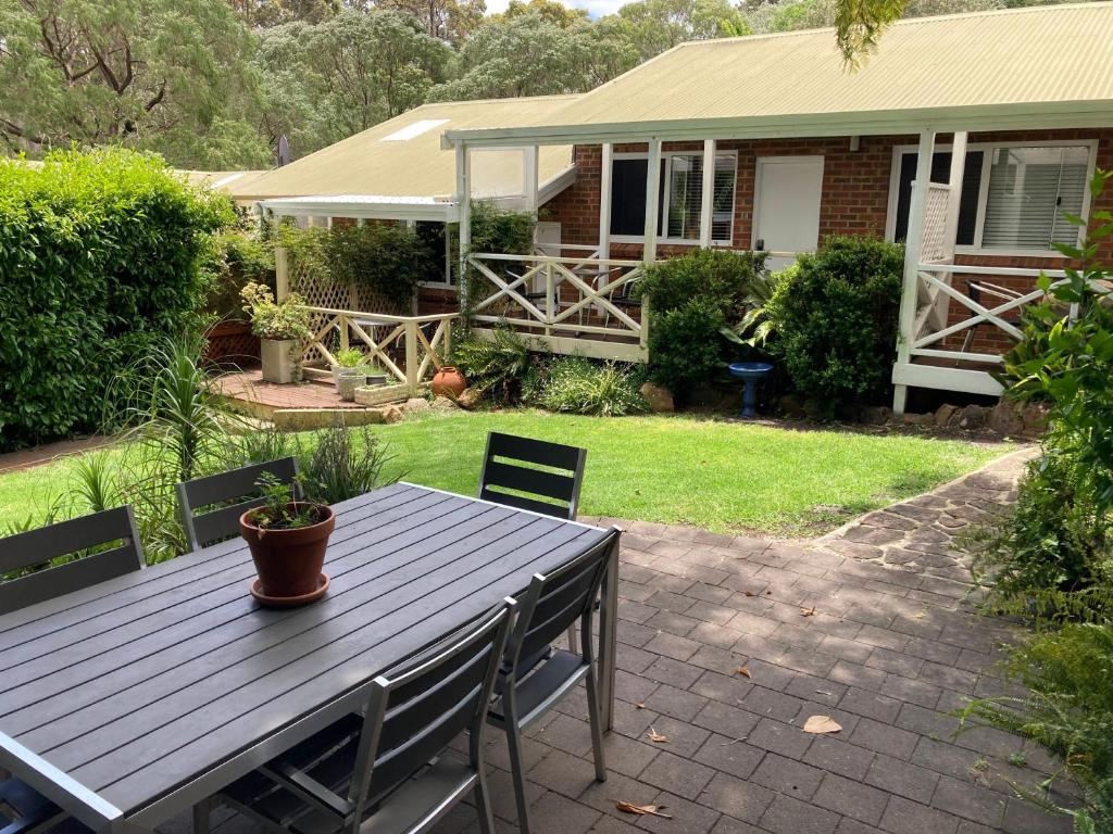 una mesa y sillas frente a una casa en Edge Of The Forest Motel en Margaret River Town