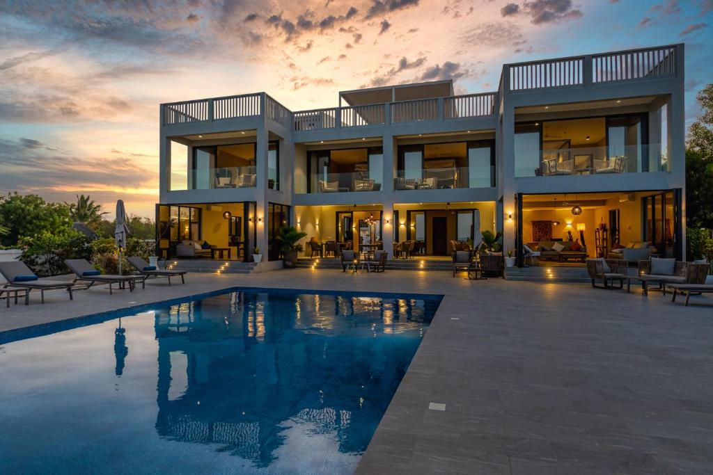 uma casa grande com uma piscina em frente em Villa Bluu em Jambiani