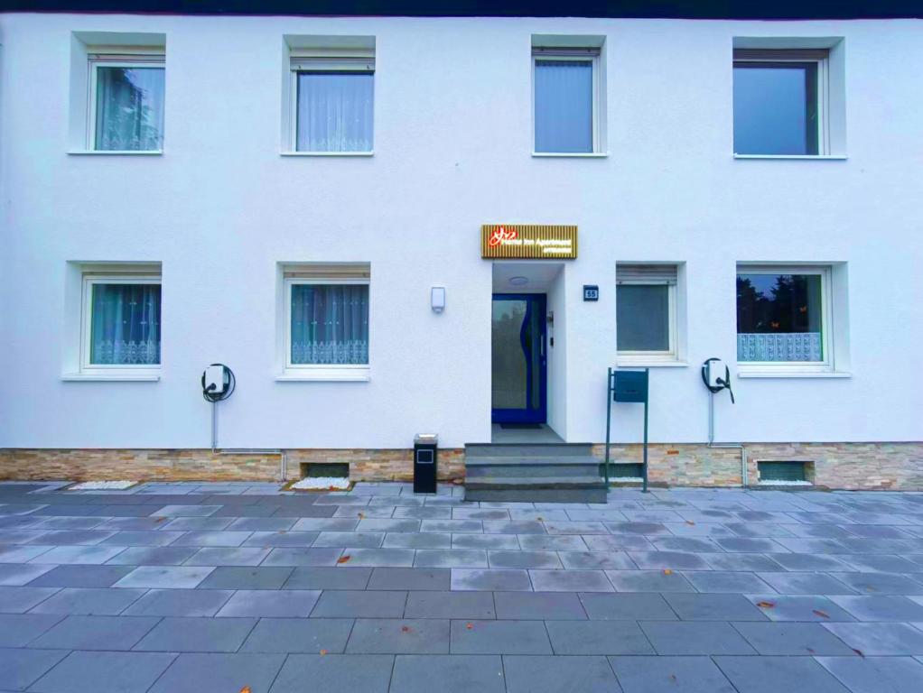 ein weißes Gebäude mit einem Schild an der Tür in der Unterkunft Home Inn Hotel in Dormagen