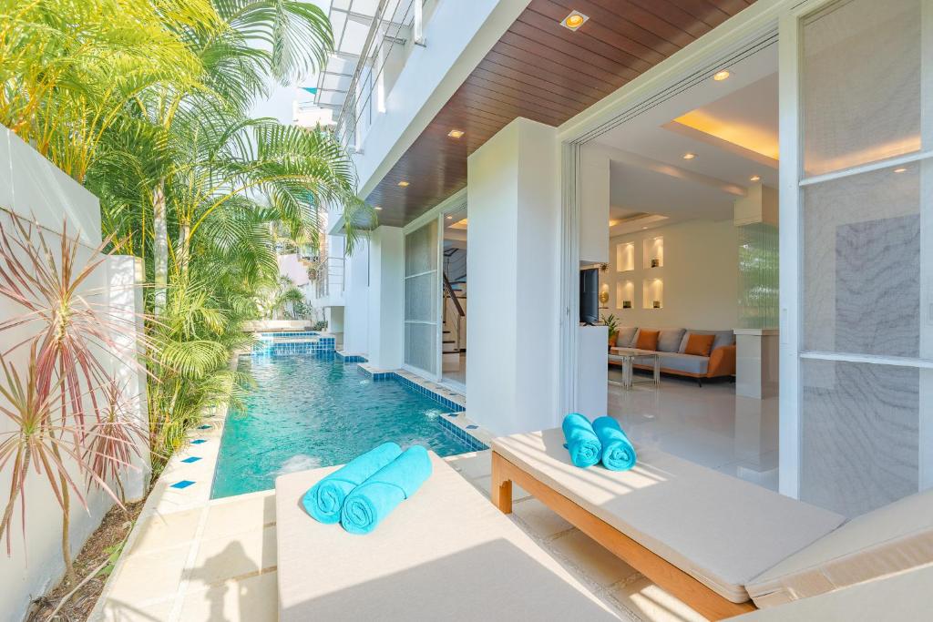 uma piscina interior numa casa com almofadas azuis em White Villa Patong em Praia de Patong