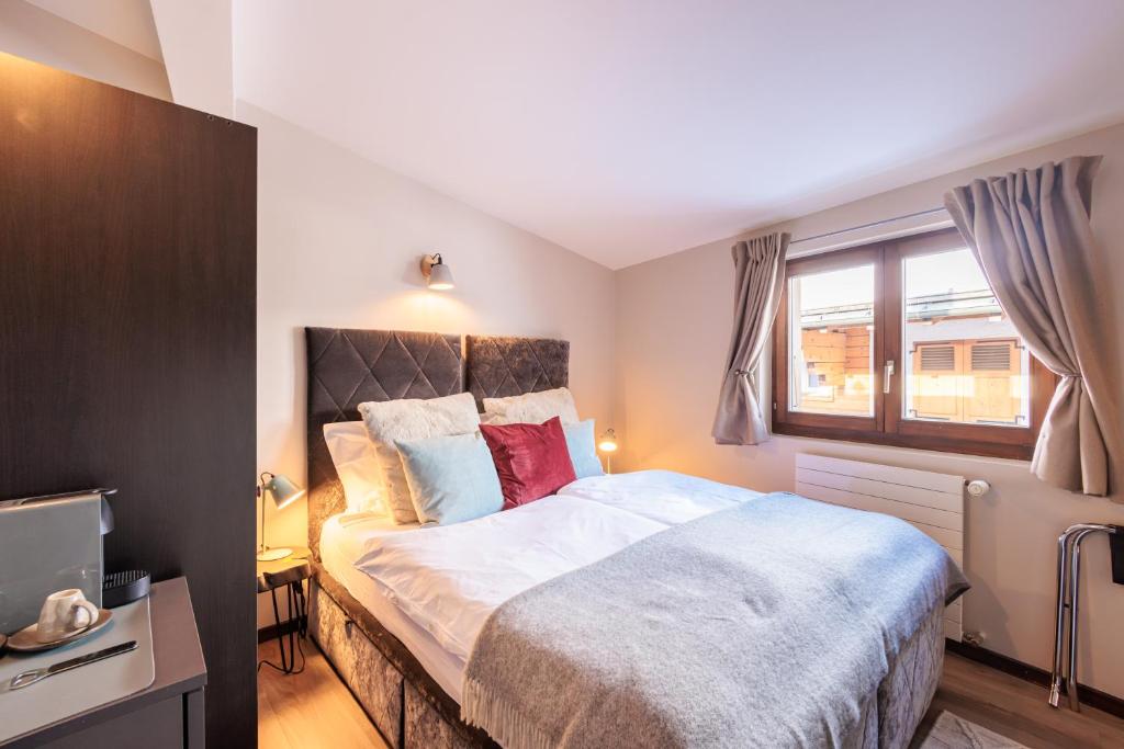 a bedroom with a large bed and a window at No 8 Bed & Bar in Verbier