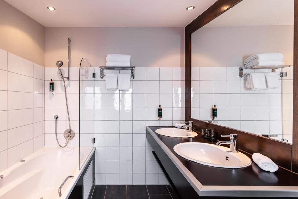 a bathroom with two sinks and a shower at No 8 Bed & Bar in Verbier