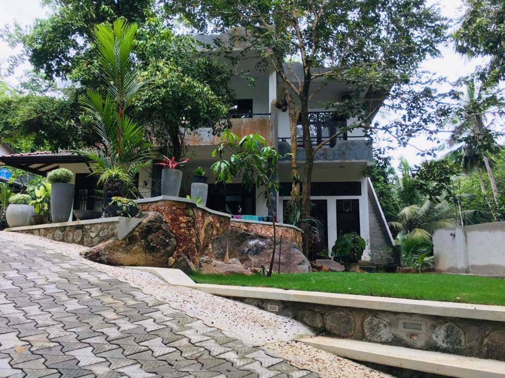 a house with a large rock in front of it at Center Point Villa Unawatuna in Unawatuna