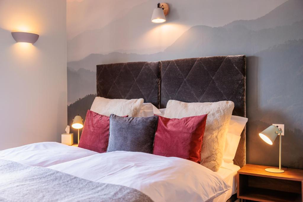 a bedroom with a large bed with colorful pillows at No 8 Bed & Bar in Verbier