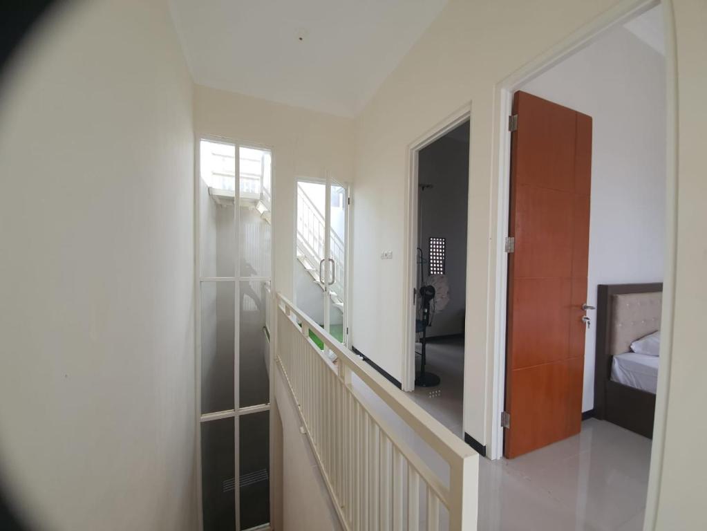 una camera con un corridoio con uno specchio e un letto di Villa Bahari Batu a Batu