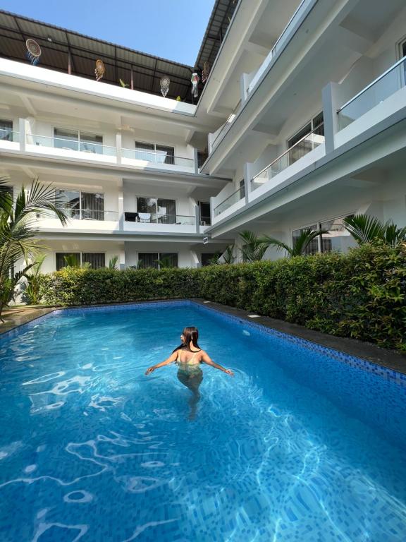 una donna che nuota in una piscina in un edificio di La Vera Boutique Hotel, Mandrem a Mandrem