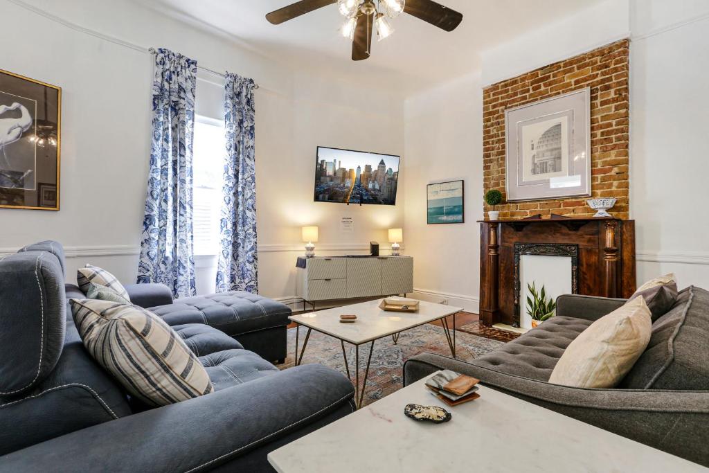 a living room with couches and a fireplace at Uptown Spacious 4BD/3BA with Historic Charm in New Orleans