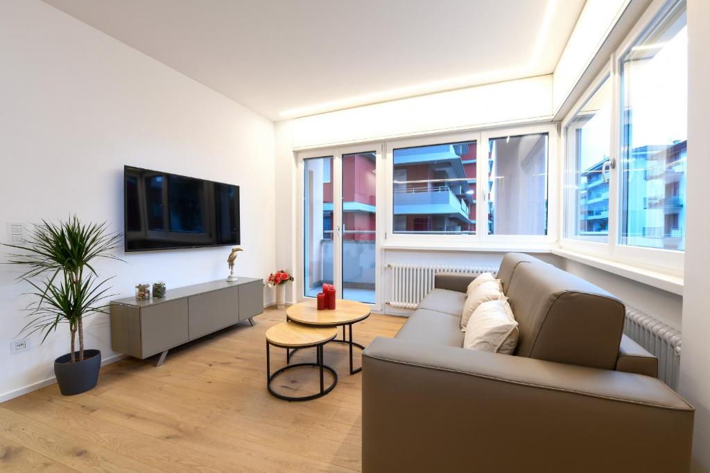 a living room with a couch and a tv at Lake Modern Suites - Free Parking in Lugano