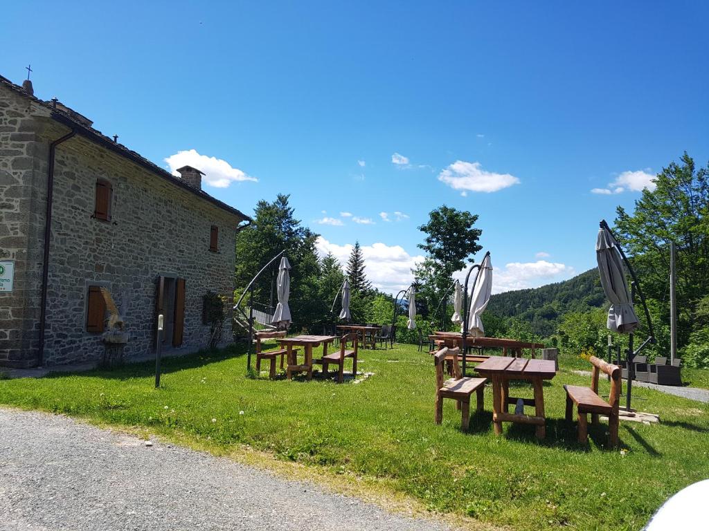 a group of picnic tables in the grass next to a building at Alpe di Sara in Fiumalbo