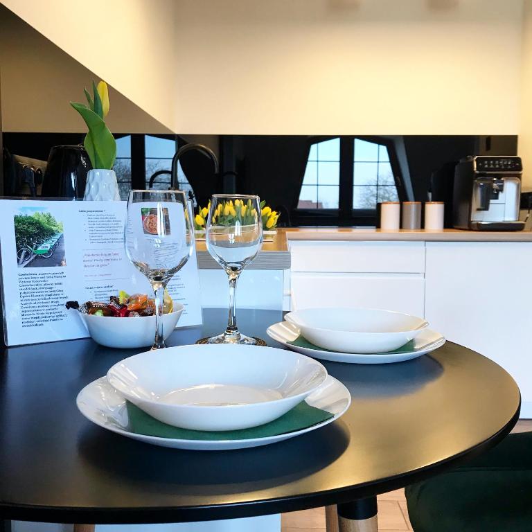 stół z dwoma kieliszkami i miską jedzenia w obiekcie Apartament Bianco Verde w mieście Częstochowa