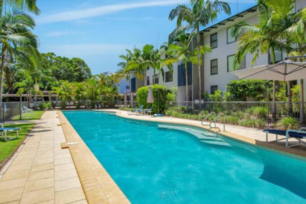 a swimming pool in front of a building at Emohruo Rainbow Shores - 3 Br Resort Apartment in Rainbow Beach