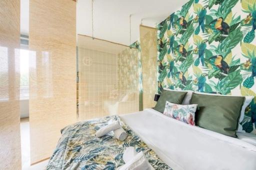 a bedroom with a bed with a floral wall at Superbe studio apartment à 2MN de Paris in Gentilly