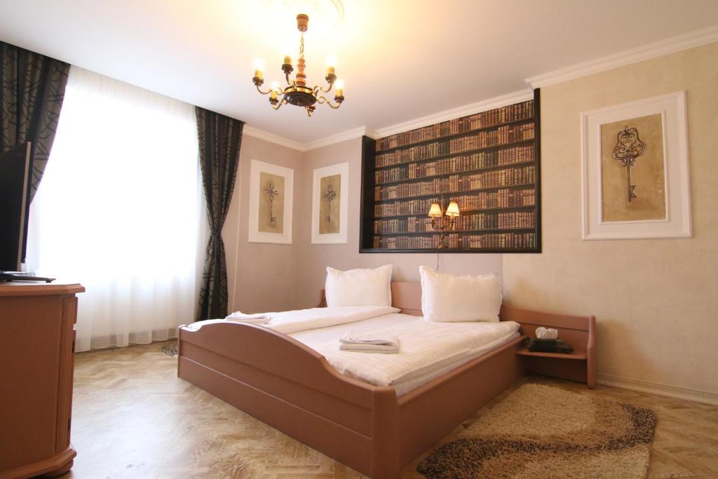 a bedroom with a bed and a chandelier at Vila Sibiu in Sibiu
