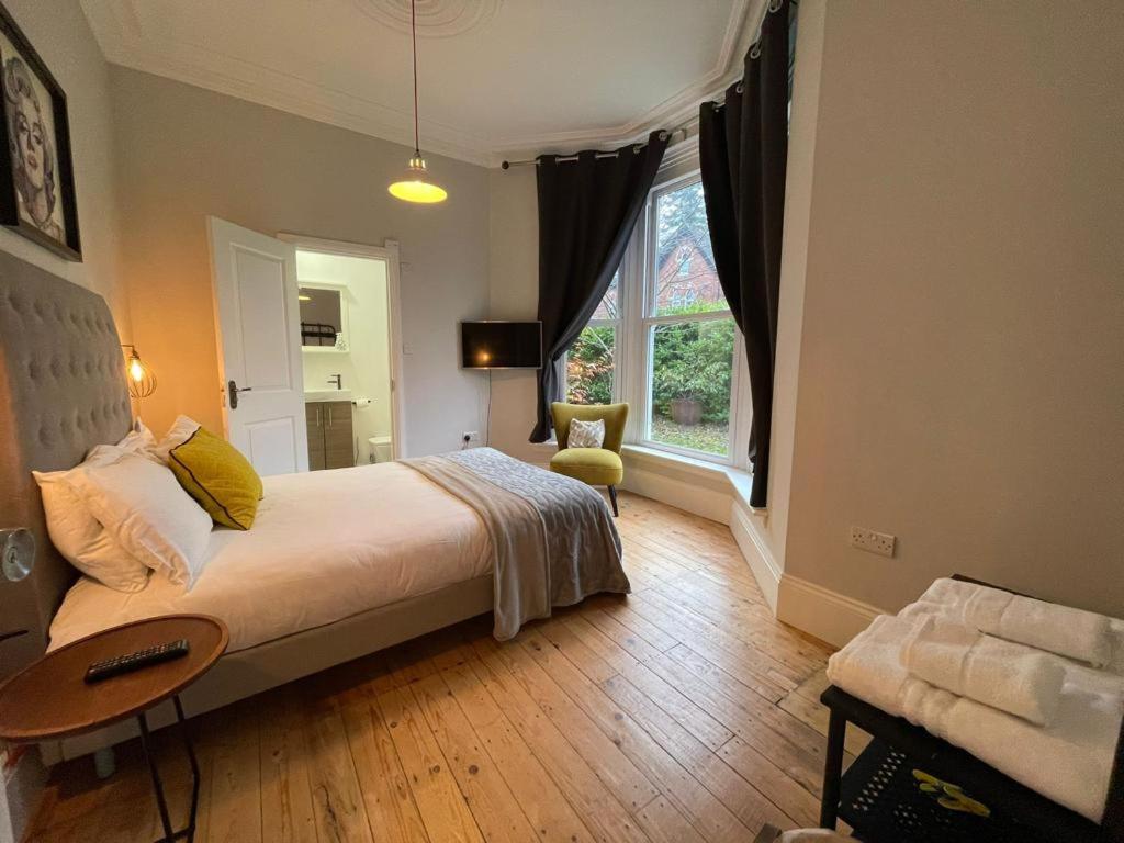 a bedroom with a large bed and a window at Urban City Suites STUNNING Victorian 3 bed 2bath with free Parking in Birmingham