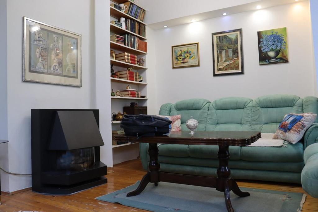 a living room with a green couch and a fireplace at Apartman Ferhadija Saraj in Sarajevo