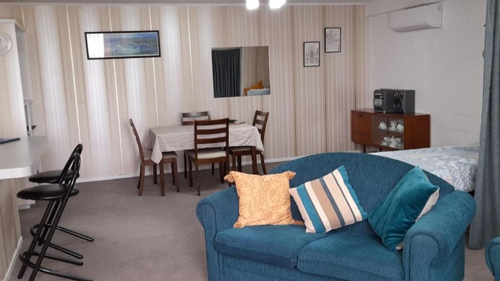 a living room with a blue couch and a table at Park View 'Home Away From Home' in Feilding