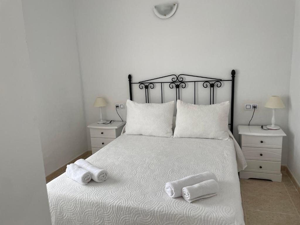 a bedroom with a bed with two towels on it at Apartamentos Dulcemar Frente al Mar con zona SPA in San José