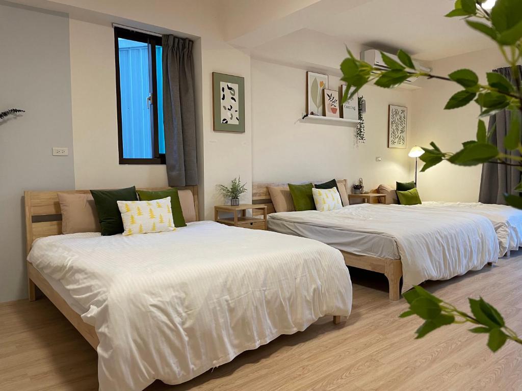 2 Betten in einem Zimmer mit weißer Bettwäsche in der Unterkunft 出水茶旅民宿 in Zhuqi