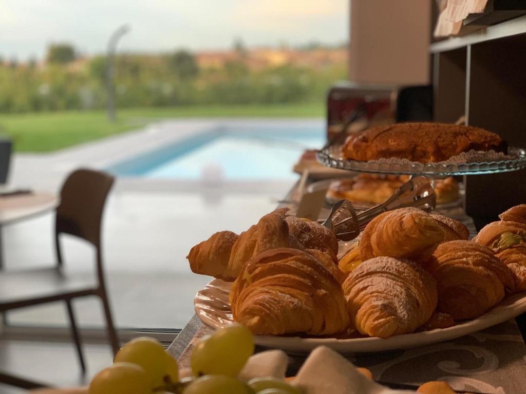 a table topped with plates of pastries and grapes at B&B Lough in Colà di Lazise